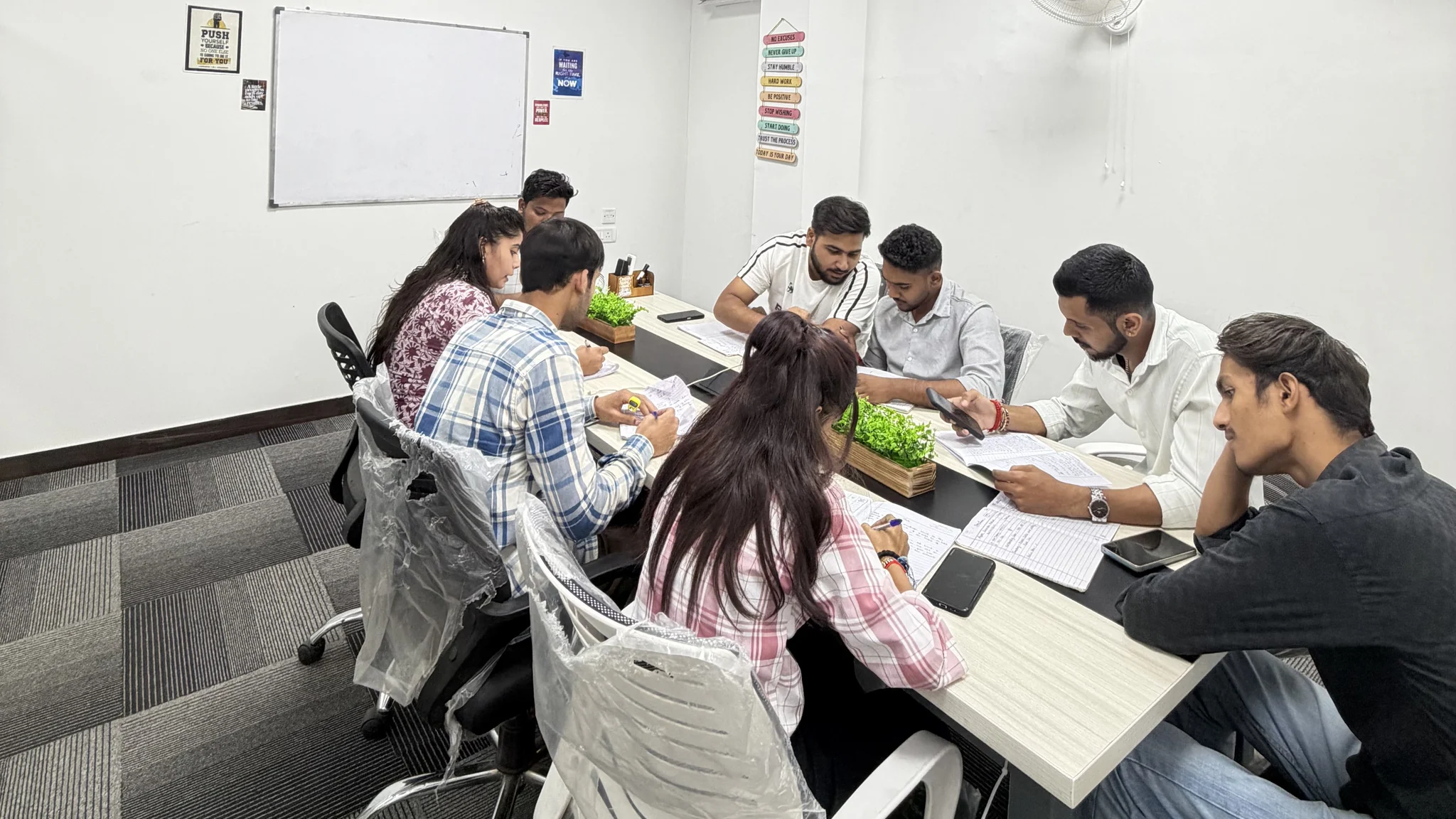 ARUNASUN team discussing records around a meeting table